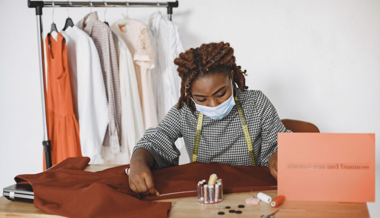 African American woman sewing clothes at her desk