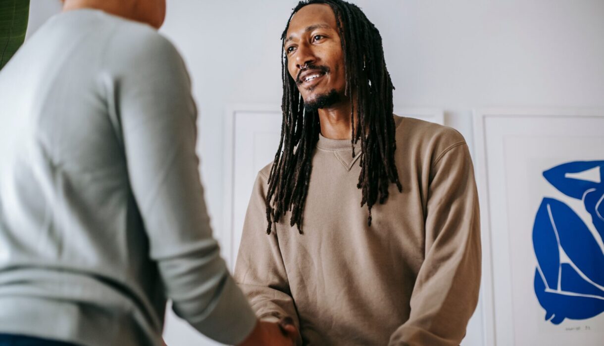 Real estate agent greeting a client with a handshake in an office