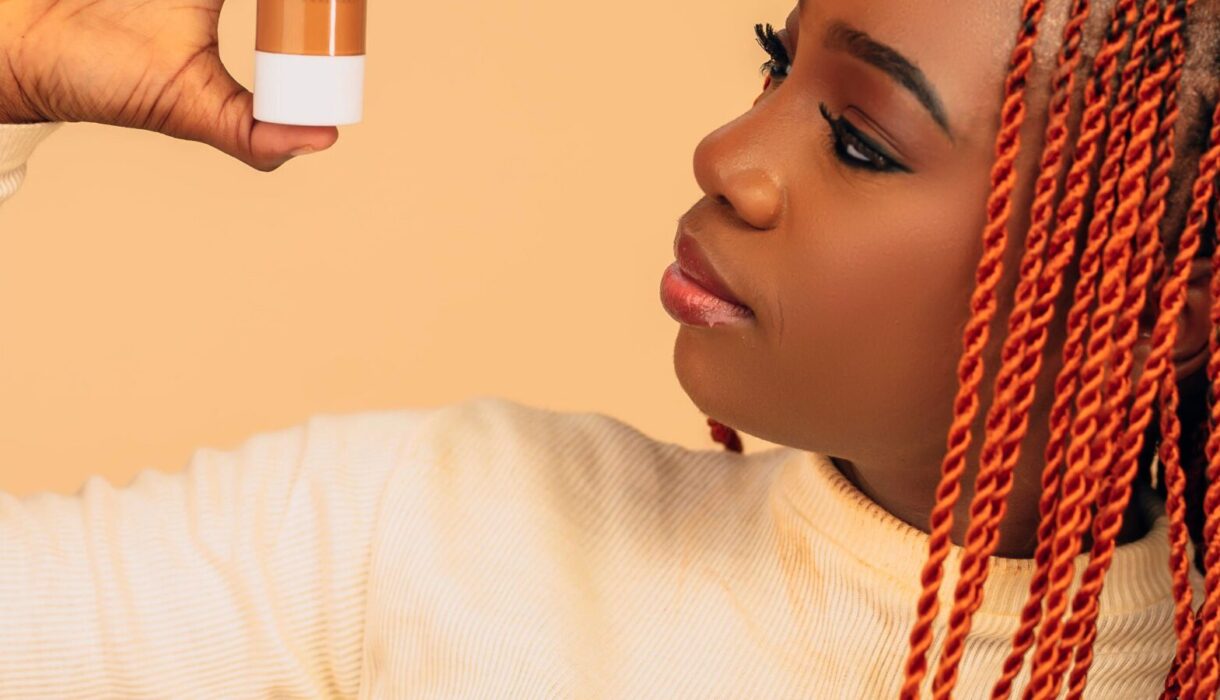 Woman with braided hair examining a skincare product