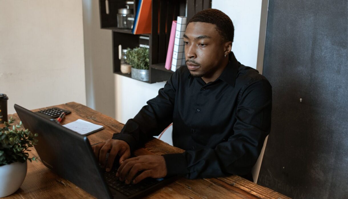 Man typing on a laptop at an office desk