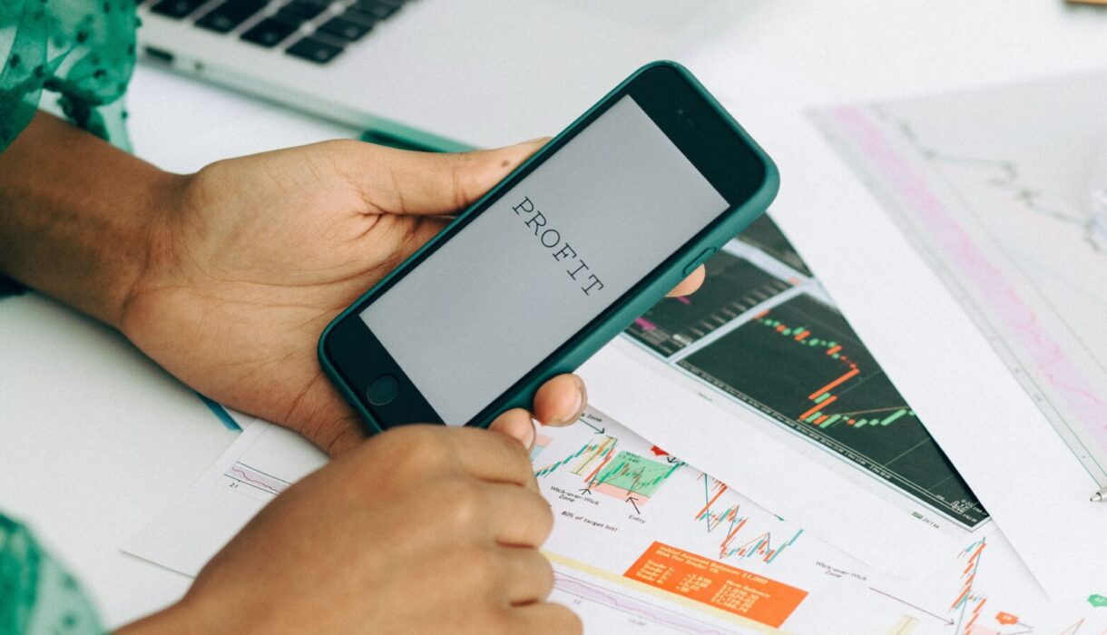 Close-up of a woman using a smartphone to analyze business data charts