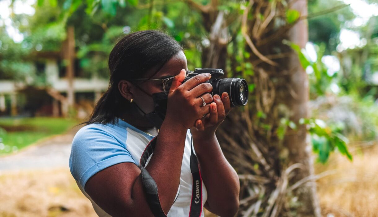 Woman taking listing photos outdoors with a DSLR camera