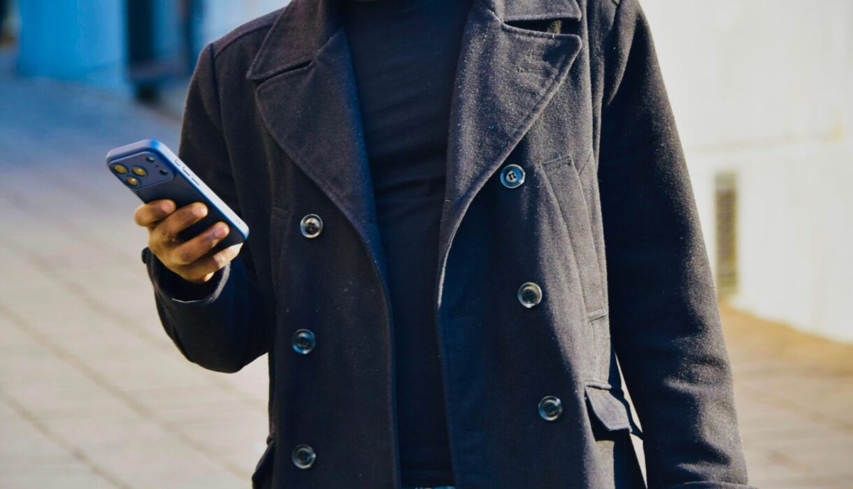 Stylish man checking his phone while shopping outdoors