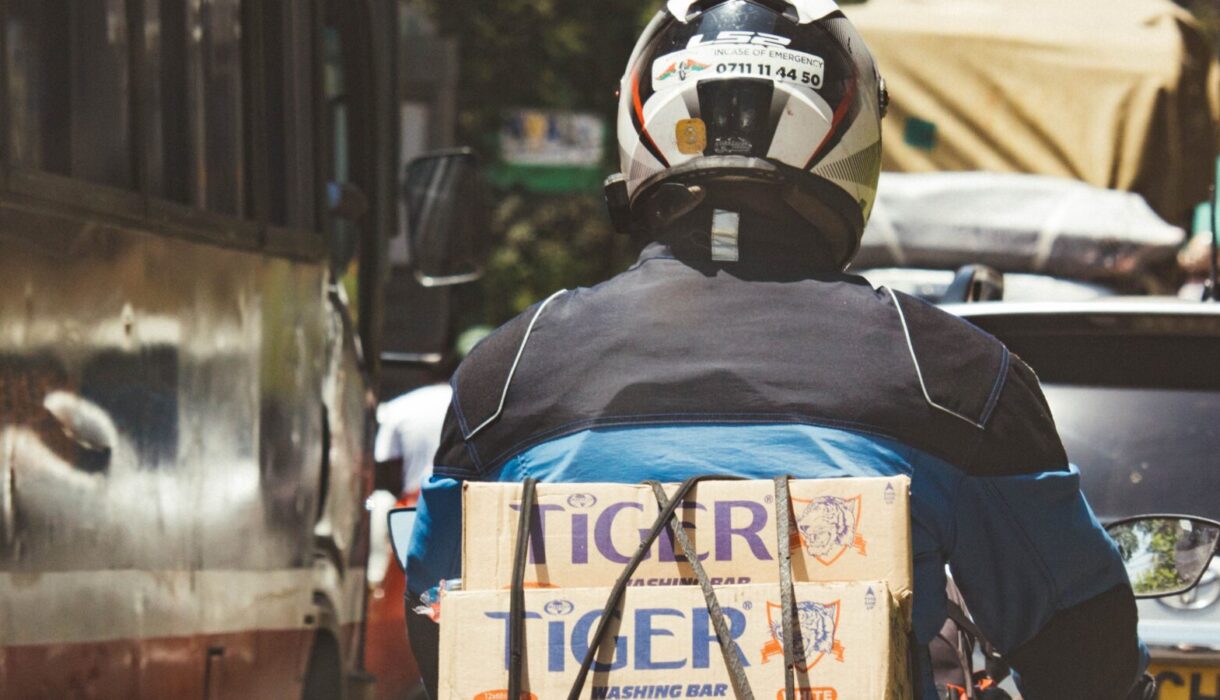 Motorcycle delivery courier navigating city traffic in Nairobi