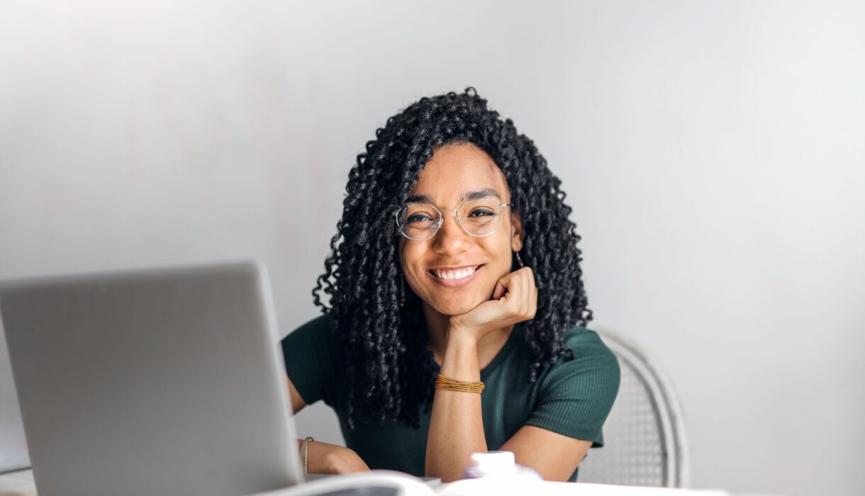 Smiling woman working on a laptop at a table
