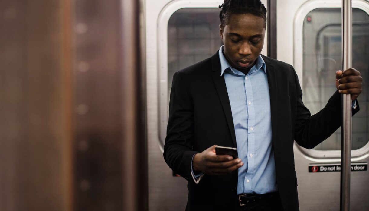Man in a suit using a smartphone on his commute