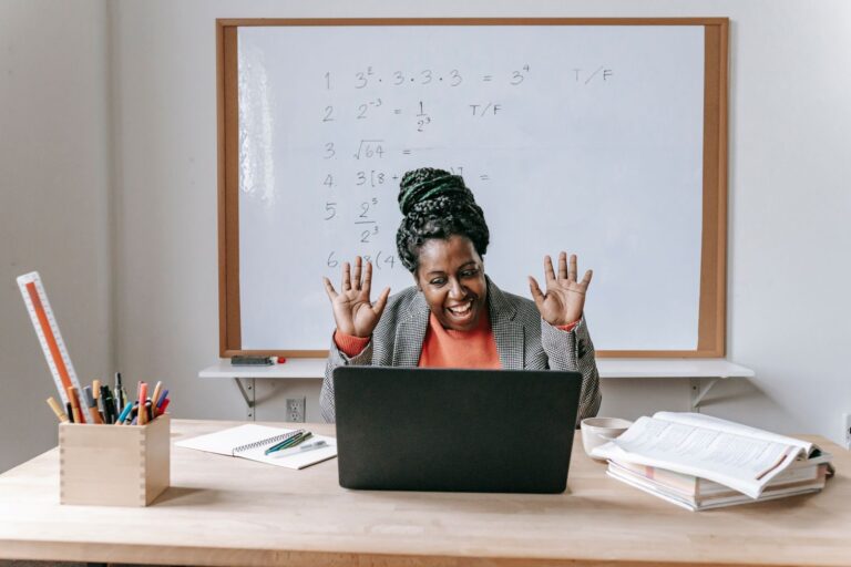 Smiling Black woman coaching online from her laptop at a table