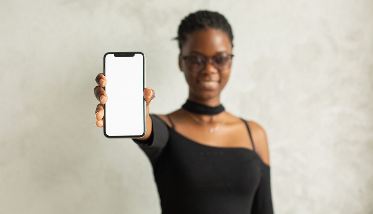 Smiling woman showing her smartphone